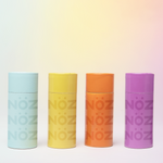 Load image into Gallery viewer, All four shades of Nöz sunscreen. From left to right: Seafoam Blue, Sunshine Yellow,  Orange Marmalade, and Dusk Purple.
